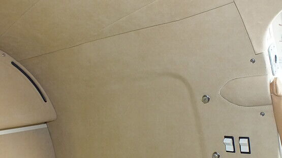 Mit nach FAR 25.853 geprüftem Aircraft-Material bezogene Verkleidungsteile einer Flugzeuginnenausstattung.